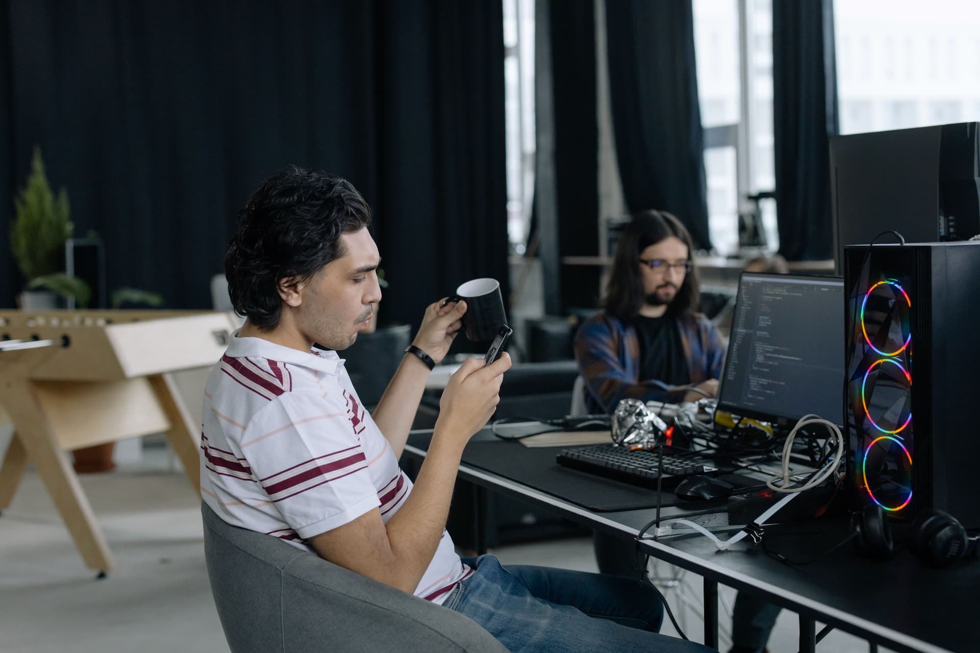 Two programmers working together at computers in a modern office